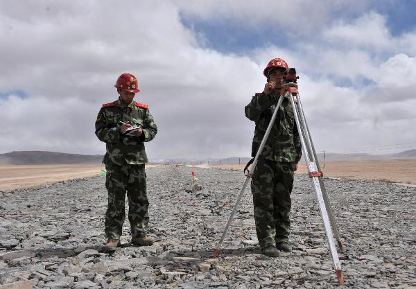 Two soldier technicians work on topographic survey on the Xinzang Road in Ritu County of Tibet Autonomous Region, on May 2, 2011.