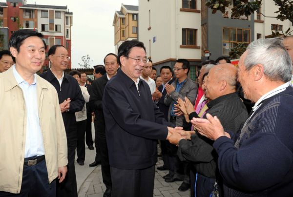 He Guoqiang (C), a member of the Standing Committee of the Political Bureau of the Communist Party of China (CPC) Central Committee and secretary of the CPC Central Commission for Discipline Inspection, shakes hands with residents as he visits a resettlement housing community in new county seat of the quake-hit Beichuan, southwest China's Sichuan Province, May 3, 2011.