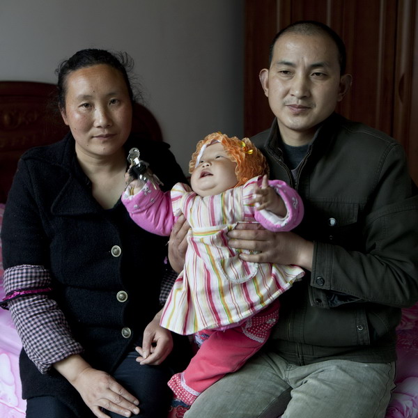 Liao Enxiang, 39, and her husband, Dai Yongcai, 41, pose with their 1-year-old daughter in Deyang, Sichuan Province, April 13, 2011. 