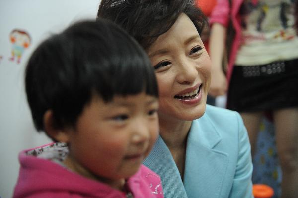 Yang Lan (L), the Chinese goodwill ambassador of the United Nations Children&apos;s Fund (UNICEF) pays a visit to the children injured during Wenchuan earthquake at Mianzhu Traditional Chinese Medicine Hospital in Mianzhu, southwest China&apos;s Sichuan Province, May 6, 2011. 