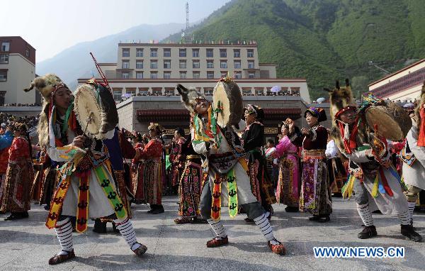 People perform a traditional stone dance during a street parade on a square in Lixian County, southwest China's Sichuan Province, May 8, 2011. 