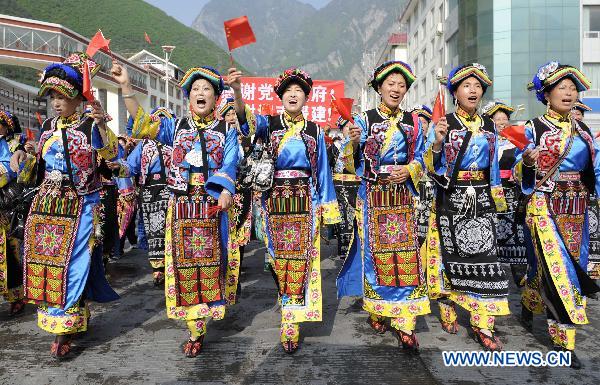 People parade in traditional costumes in Lixian County, southwest China's Sichuan Province, May 8, 2011. 
