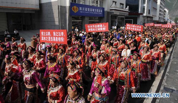 People parade in traditional costumes in Lixian County, southwest China's Sichuan Province, May 8, 2011. 
