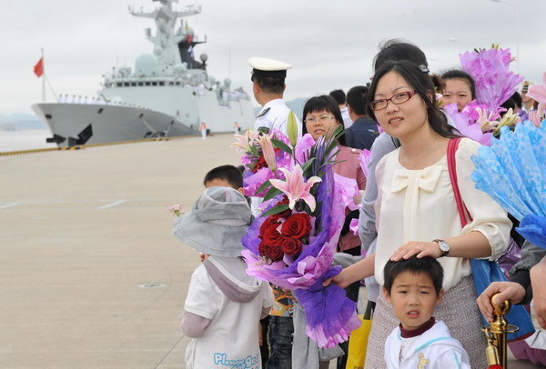 People with flowers wait prior to a welcome ceremony for the return of Chinese Navy Seventh Escort Task Force in Zhoushan, east China&apos;s Zhejiang Province, May 9, 2011.