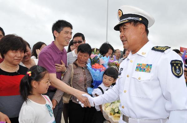 Li Jianjun, a commander of Chinese Navy Seventh Escort Task Force, shakes hands with fellow countrymen during a welcome ceremony in Zhoushan, east China&apos;s Zhejiang Province, May 9, 2011. 