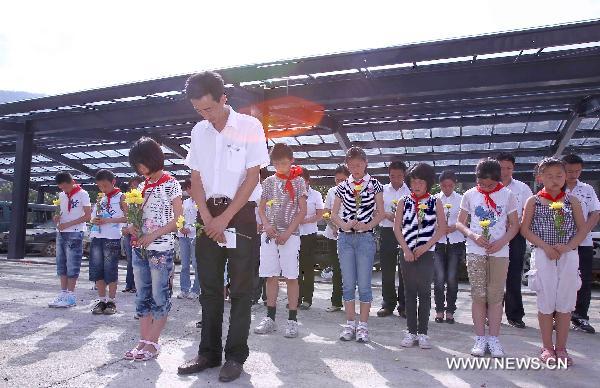 Teachers and students mourn those teachers and students killed in the massive earthquake three years ago at the original site of Qushan Primary School in Beichuan County, southwest China's Sichuan Province, May 10, 2011. The massive Wenchuan earthquake on May 12, 2008, destroyed the Qushan Primary School and killed 410 teachers and students of the school.