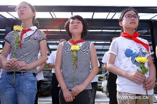 Students mourn those teachers and students killed in the massive earthquake three years ago at the original site of Qushan Primary School in Beichuan County, southwest China's Sichuan Province, May 10, 2011.