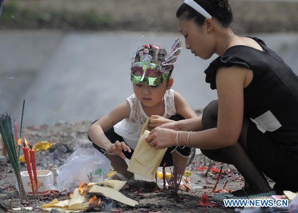 Li Qingjiang and her daughter burn joss paper to commemorate their beloved families lost in the 2008 Wenchuan earthquake in Beichuan, southwest China&apos;s Sichuan Province, May 12, 2011.