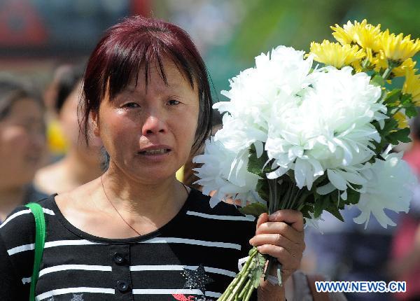 A woman holds a bunch of flowers to commemorate their beloved families lost in the 2008 Wenchuan earthquake in Beichuan, southwest China&apos;s Sichuan Province, May 12, 2011.