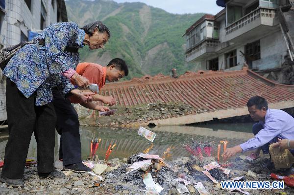 People burn joss paper to commemorate their beloved families lost in the 2008 Wenchuan earthquake in Beichuan, southwest China's Sichuan Province, May 12, 2011.