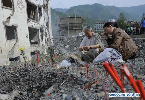 People burn joss paper to commemorate their beloved families lost in the 2008 Wenchuan earthquake in Beichuan, southwest China's Sichuan Province, May 12, 2011. 