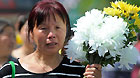 A woman holds a bunch of flowers to commemorate their beloved families lost in the 2008 Wenchuan earthquake in Beichuan, southwest China's Sichuan Province, May 12, 2011.