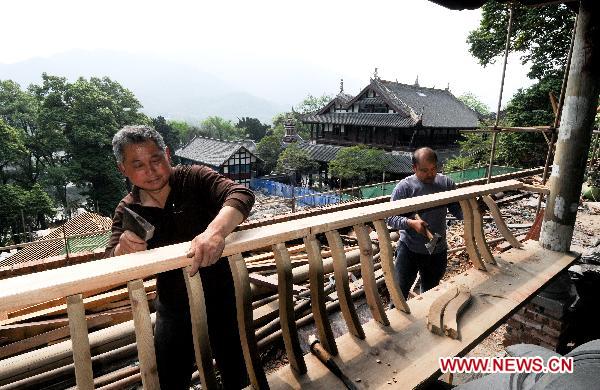 Photo taken on April 25, 2011 shows workers restore the ancient buildings around the Erwang Temple in Dujiangyan City, southwest China's Sichuan Province.