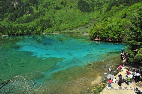 Tourists visit the peacock lake in the Jiuzhaigou scenery spot in southwest China's Sichuan Province, on May 18, 2011. After three years' remedy and recovery, Jiuzhaigou, a renowned resort once had been badly affected by a deadly earthquake, is booming in its tourism business, with the daily reception number reaching nearly 10,000 in May. (Xinhua/Chen Haining) (hdt) 
