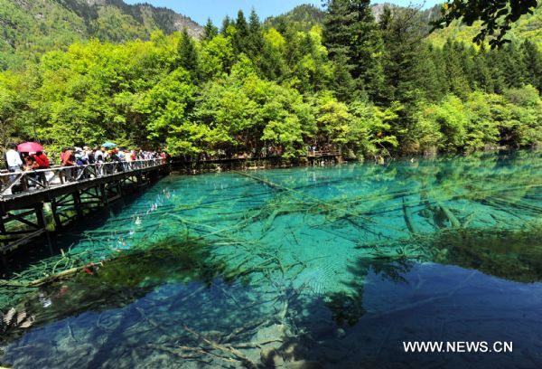 Tourists visit the Jiuzhaigou scenery spot in southwest China's Sichuan Province, on May 18, 2011. After three years' remedy and recovery, Jiuzhaigou, a renowned resort once had been badly affected by a deadly earthquake, is booming in its tourism business, with the daily reception number reaching nearly 10,000 in May. (Xinhua/Chen Haining) (hdt) 