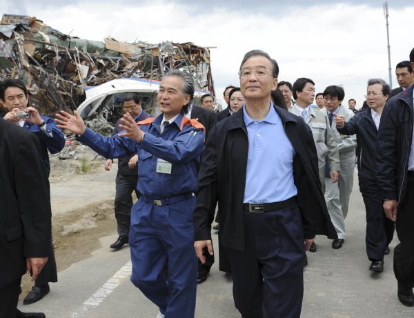 Chinese Premier Wen Jiabao (R, front) visits the area damaged by the March 11 earthquake and tsunami in Natori city, Japan, May 21, 2011.