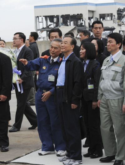 Chinese Premier Wen Jiabao (C, front) visits the area damaged by the March 11 earthquake and tsunami in Natori city, Japan, May 21, 2011. 