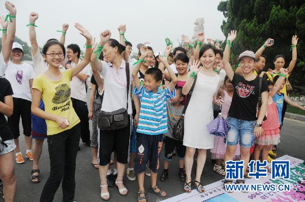 Tourists, citizens and students take a group photo at a hike to promote a low-carbon lifestyle in Nanjing, Jiangsu Province, July 10, 2011. 