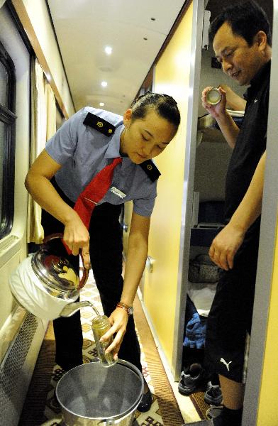 Liu Yang, an attendant, serves the drink in the T27 train from Beijing, capital of China, to Lhasa, southwest China's Tibet Autunomous Region, July 17, 2011. 