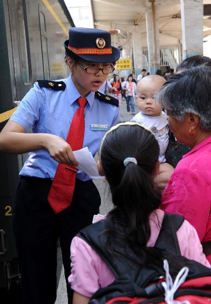 Li Jin, an attendant, serves the passengers after the T27 train from Beijing, capital of China, to Lhasa, southwest China's Tibet Autunomous Region, arrives at Lanzhou Station, July 18, 2011.