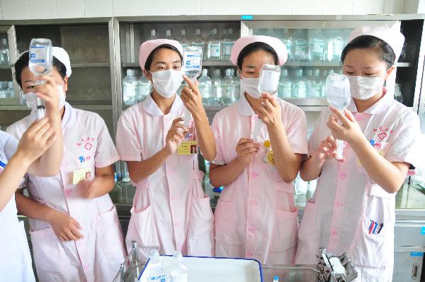 Students of Tibetan ethnic group practise as nurses at a hospital in Nanchong City, southwest China's Sichuan Province, July 18, 2011. 