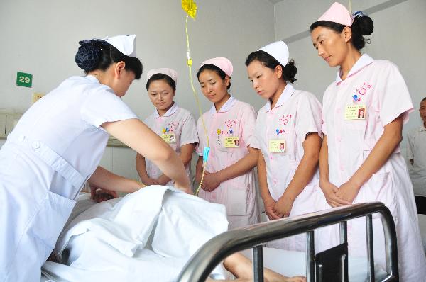Students of Tibetan ethnic group practise as nurses at a hospital in Nanchong City, southwest China's Sichuan Province, July 18, 2011.