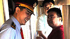 Gu Xingfu (L), a conductor, talks with passengers in the T27 train from Beijing, capital of China, to Lhasa, southwest China's Tibet Autunomous Region, July 18, 2011.