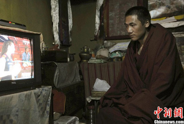 A young monk is watching his favorite TV program at dormitory. Free digital TV programs are available in more than 500 dormitories in the Sera Monastery, one of the three major monasteries of the Gelug Sect in Lhasa, southwest China&apos;s Tibet Autonomous Region.