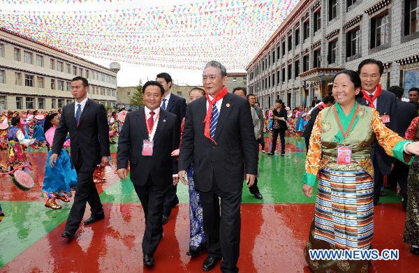 Ragdi (C Front), a deputy leader of the delegation of the central government, visits a primary school in Lhasa, capital of southwest China's Tibet Autonomous Region, July 21, 2011. 