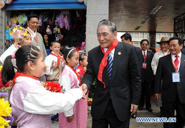 Ragdi (C), a deputy leader of the delegation of the central government, visits a primary school in Lhasa, capital of southwest China's Tibet Autonomous Region, July 21, 2011. 