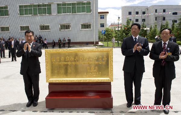 Chinese Vice Premier Hui Liangyu (L) presents a plaque bearing an inscription by Chinese President Hu Jintao, which says 'Congratulations on the 60th anniversary of the peaceful liberation of Tibet' during a visit to Shannan Prefecture, southwest China's Tibet Autonomous Region, July 21, 2011.