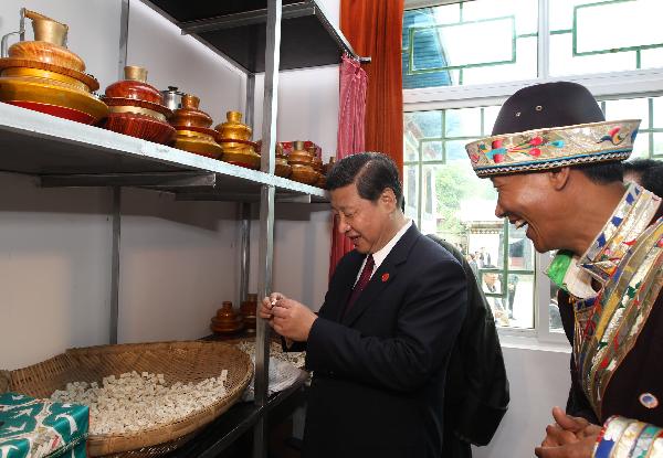 Chinese Vice President Xi Jinping (C) tastes a piece of cheese at a Tibetan household during a visit to the village of Bagyi in Nyingchi Prefecture, southwest China's Tibet Autonomous Region, July 21, 2011. 