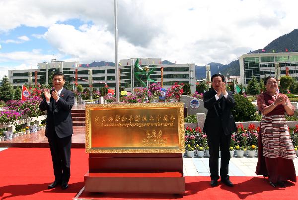 Chinese Vice President Xi Jinping (L) presents to the local government a plaque bearing an inscription by Chinese President Hu Jintao, which says 'Congratulations on the 60th anniversary of the peaceful liberation of Tibet' during a visit to Nyingchi Prefecture, southwest China's Tibet Autonomous Region, July 21, 2011. 