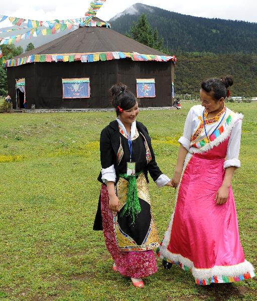 Young girls wait for tourists in Nyingchi of southwest China's Tibet Autonomous Region, July 3, 2011.