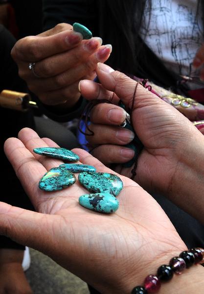 A tourist selects kallaite in a market in Lhasa, capital of southwest China's Tibet Autonomous Region, July 24, 2011. 