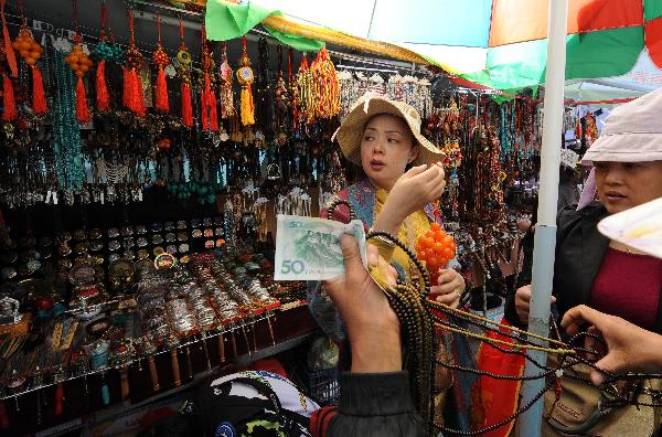 Tourists are seen in a market in Lhasa, capital of southwest China's Tibet Autonomous Region, July 24, 2011. 