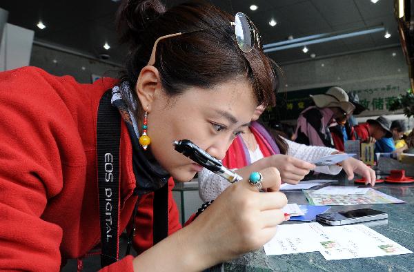 A tourist writes postcards in a postal office in Lhasa, capital of southwest China's Tibet Autonomous Region, July 24, 2011. 