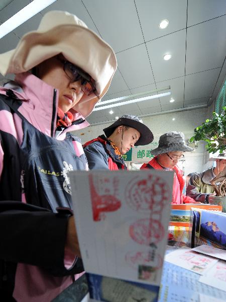 A tourist selects postcards in a postal office in Lhasa, capital of southwest China's Tibet Autonomous Region, July 24, 2011.