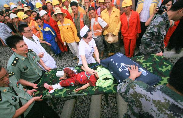 Rescuers carry an injured child and rush to sent him to a hospital at the site where the high-speed train crash occurred in Wenzhou, east China's Zhejiang Province, July 24, 2011. 