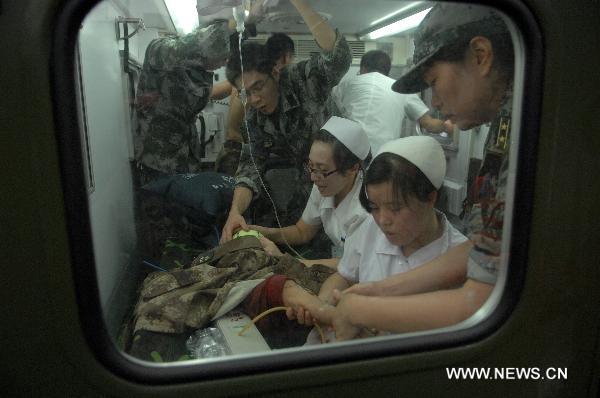 Nurses give emergency medical treatment to a toddlers who is just rescued from the wreckage of a bullet train in Wenzhou, east China's Zhejiang Province, July 24, 2011.