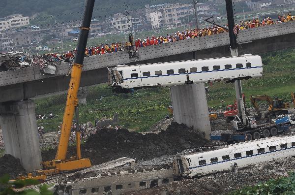 Cranes lift derailed train carriages at the site where the high-speed train crash occurred in Wenzhou, east China's Zhejiang Province, July 24, 2011. 