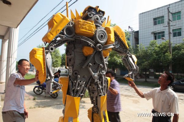 Citizens watch a 'transformer Bumblebee' made by a welder in Zhijiang City, central China's Hubei Province, July 25, 2011. 