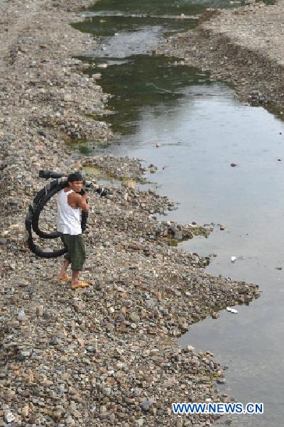 A farmer prepares to install irrigation equipments in Tonglin Township of Sansui County, southwest China's Guizhou Province, Aug. 1, 2011.