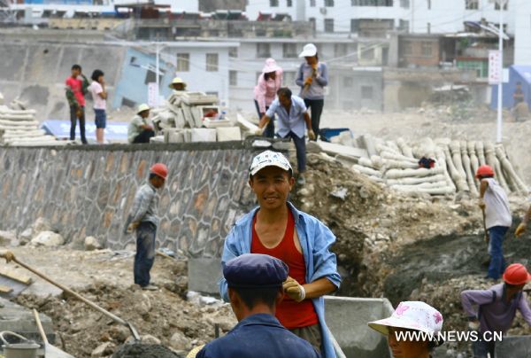 A worker is seen grinning at a building site in Zhouqu County of Gannan Tibetan Autonomous Prefecture, northwest China's Gansu Province, Aug. 2, 2011. 