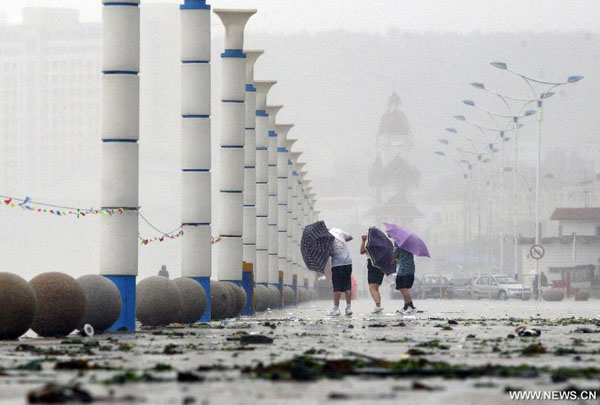 Citizens walk against wind as a fierce storm brought by Typhoon Muifa hits Yantai, a coastal city in east China&apos;s Shandong Province, Aug. 8, 2011.