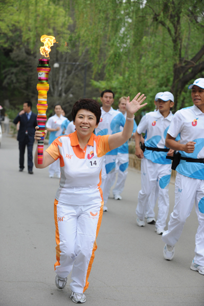 Torchbearer Deng Yaping runs with the torch during the torch relay for the 26th Summer Universiade at Shenzhen, south China&apos;s Guangdong Province, on May 4, 2011.