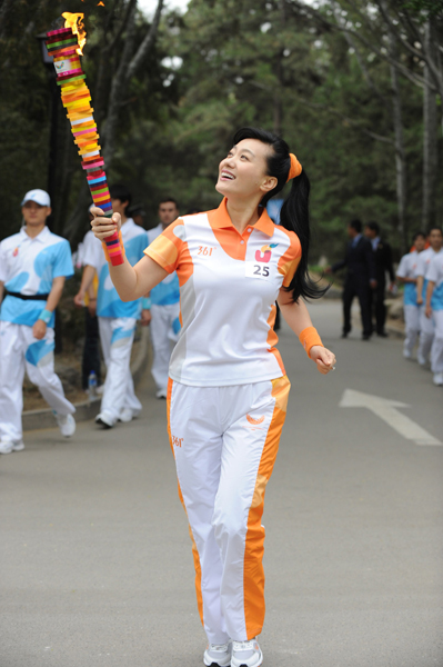 Torchbearer Tan Jing runs with the torch during the torch relay for the 26th Summer Universiade at Shenzhen, south China&apos;s Guangdong Province, on May 4, 2011.