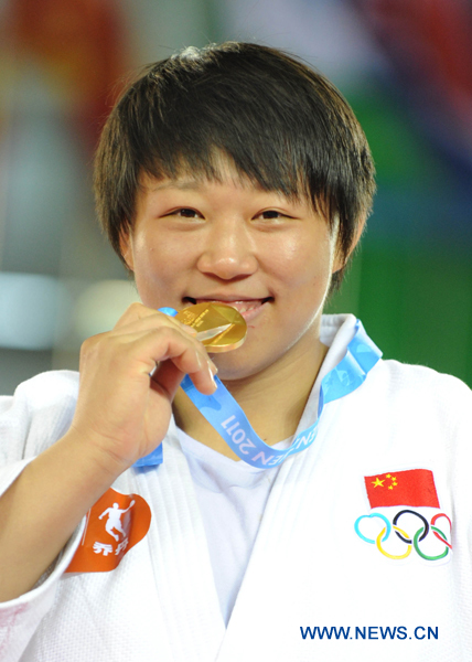 China's Qin Qian kisses the gold medal after winning the women's Judo +78 KG final match against South Korea's Kim Na Young at the 26th Summer Universiade in Shenzhen, a city of south China's Guangdong Province, Aug. 13, 2011.