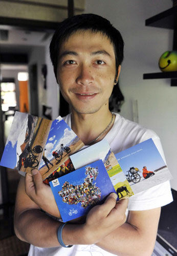Zhou Ziqian shows postcards that display photos he took of people posing with UU, the mascot for the Shenzhen Summer Universiade, in Shenzhen, Guangdong Province, on August 14, 2011. 