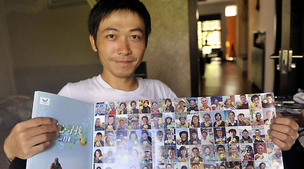 Zhou Ziqian shows photos of people posing with UU, the mascot for the Shenzhen Summer Universiade, in Shenzhen, Guangdong Province, on August 14, 2011.